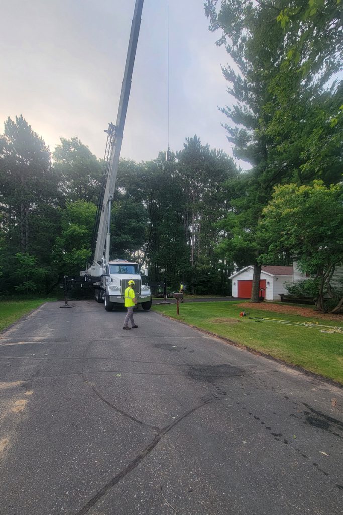 Crane truck operating on residential street with workers