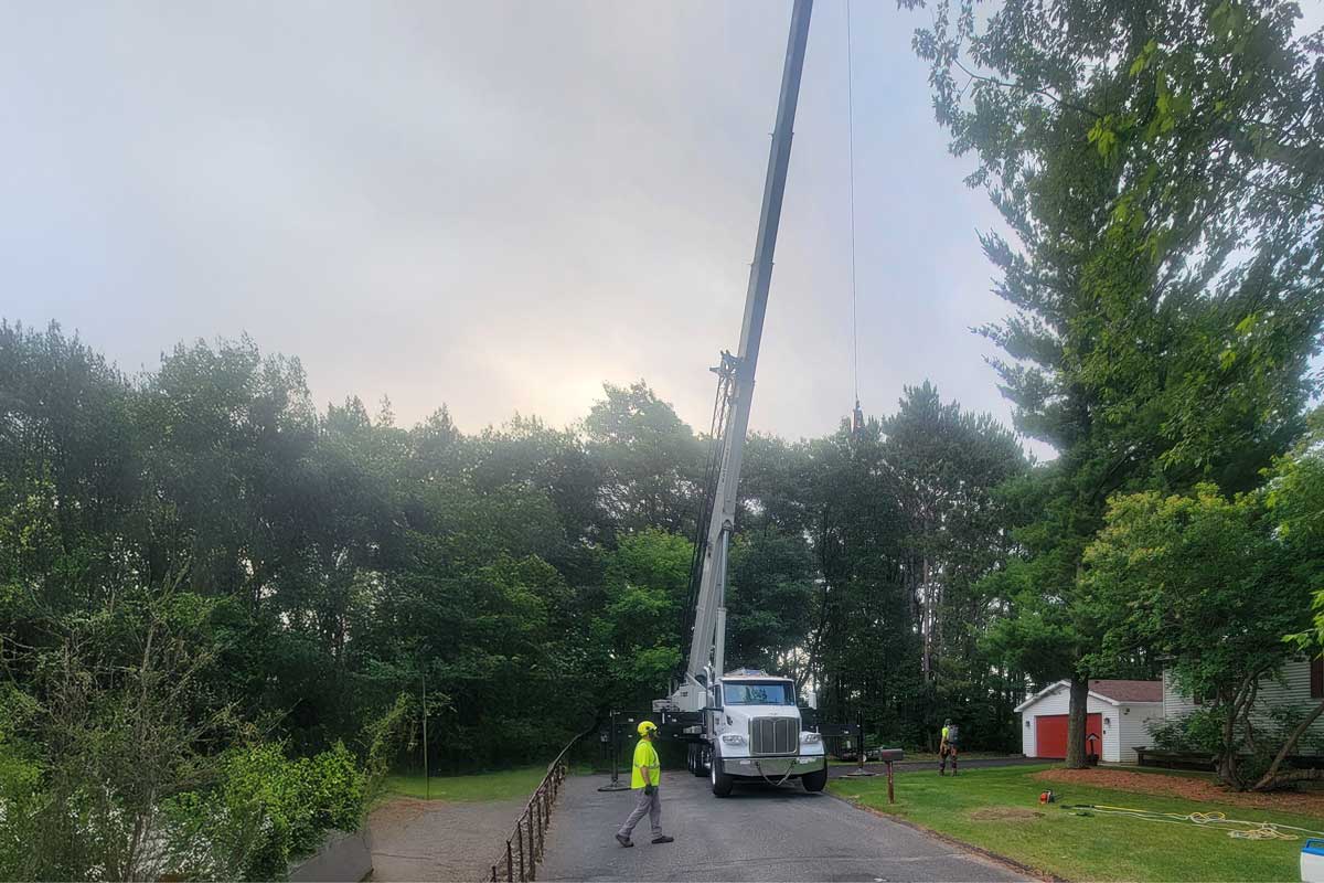 Crane truck operating on residential street with workers